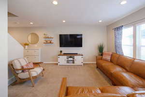 Living area featuring light carpet and recessed lighting