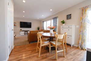Dining space with light wood-type flooring and recessed lighting
