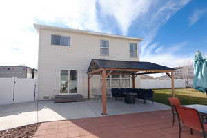 Back of house featuring a patio, a gate, a gazebo, and a fenced backyard