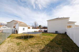 Fenced backyard with a gazebo, a trampoline, a patio area, and a storage unit