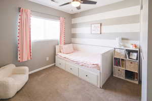 Bedroom with light carpet and a ceiling fan