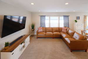 Living room with light carpet and recessed lighting