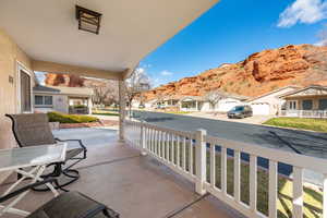 Covered porch featuring a residential view and a mountain view