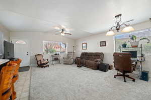 Living room featuring lofted ceiling, plenty of natural light, ceiling fan, and light colored carpet