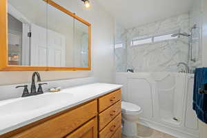 Full bathroom with vanity and a marble finish shower