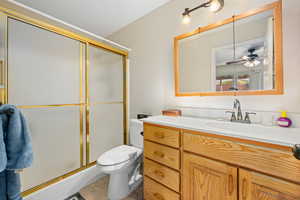 Bathroom with vanity, a stall shower, and ceiling fan