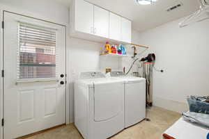 Laundry room with washer and clothes dryer and cabinet space
