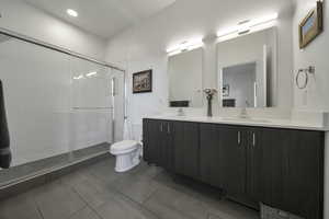 Bathroom with double vanity, a stall shower, and recessed lighting