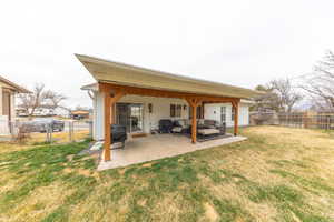 Back of house featuring modern wooden beams/posts , creating a nice  outdoor hangout area.
