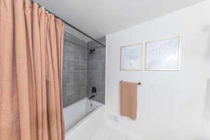 Full main bathroom with oversized  shower / tub combo and modern tile surround