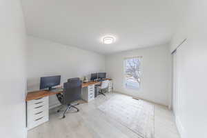 Office /bedroom area with light wood finished floors and baseboards