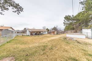 Fenced backyard with a storage shed, a patio, and a vegetable garden