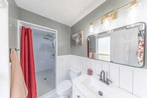 Owner’s bathroom with vanity, large custom tiled double shower , and wainscoting