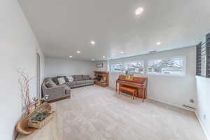 Family room with recessed lighting, a brick fireplace , beautiful big well lit windows