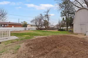 Fenced backyard featuring an outdoor structure