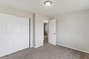 Unfurnished bedroom featuring carpet flooring and a closet