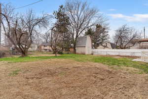 Fenced backyard with an outdoor structure