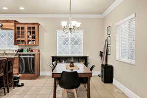 Dining space featuring light tile patterned floors, hanging lights, and ornamental molding