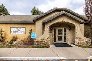 Property entrance with stone siding and stucco siding