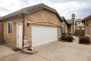 View of front of home featuring a garage, stucco siding, and concrete driveway