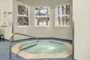 View of swimming pool with an in-ground hot tub