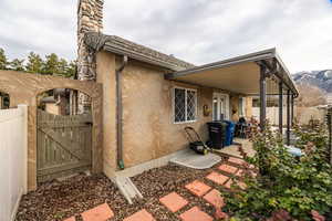 Back of property with stucco siding and a gate