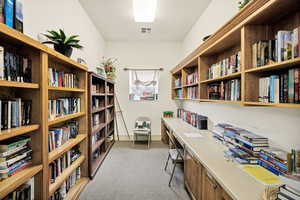Office area featuring light carpet and a textured ceiling