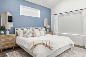Carpeted bedroom featuring vaulted ceiling