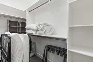 Walk in closet featuring dark colored carpet