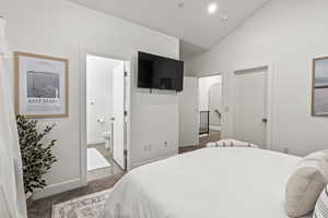 Bedroom with light carpet, vaulted ceiling, ensuite bathroom, and recessed lighting