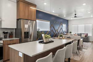 Dual tone kitchen featuring modern cabinets, stainless steel appliances, open floor plan, dual tone cabinets, and ceiling fan