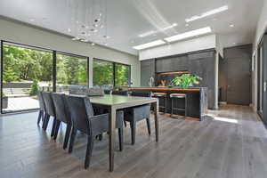 Dining room with a skylight, light wood-style flooring, and recessed lighting