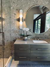 Bathroom with vanity, a stall shower, and decorative backsplash