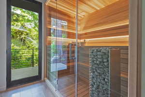 Bathroom featuring a sauna, wood walls, a shower stall, and wood ceiling