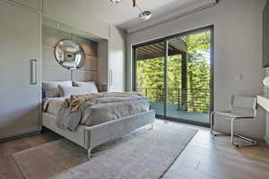 Bedroom with wood finished floors and access to outside