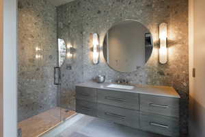 Bathroom with vanity, tile walls, and a stall shower