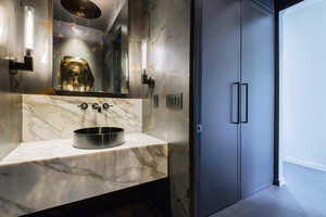 Bathroom with vanity, tasteful backsplash, and dark tile patterned floors