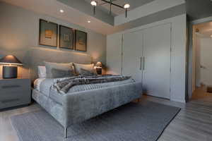 Bedroom with light wood-style flooring, a closet, and a chandelier