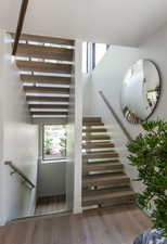 Stairway featuring wood finished floors and plenty of natural light