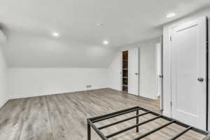 Additional living space featuring light wood-style flooring, recessed lighting, and lofted ceiling