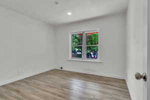 Empty room with light wood-type flooring and recessed lighting