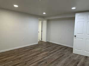 Empty room with recessed lighting and dark wood-style flooring