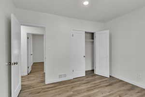 Unfurnished bedroom featuring light wood-style flooring and a closet