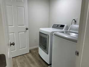 Laundry area featuring washing machine and clothes dryer and wood finished floors