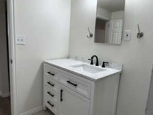 Bathroom featuring vanity and a textured wall