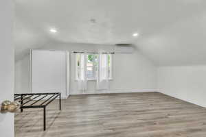 Additional living space featuring lofted ceiling, light wood-type flooring, and recessed lighting
