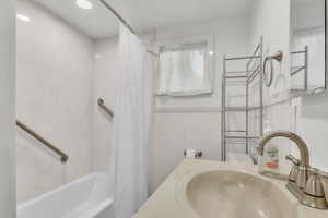Bathroom with vanity, shower / bath combo with shower curtain, and recessed lighting