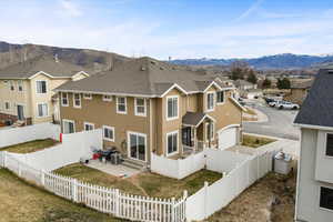 Back of property with stucco siding, a residential view, a mountain view, and a patio area