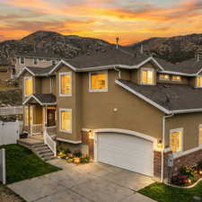 Traditional-style home with brick siding, concrete driveway, stucco siding, a garage, and covered porch