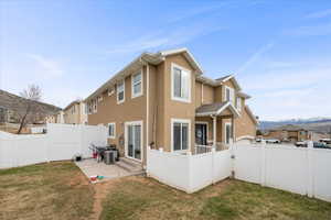 Back of house featuring a fenced backyard, stucco siding, a mountain view, and a patio area